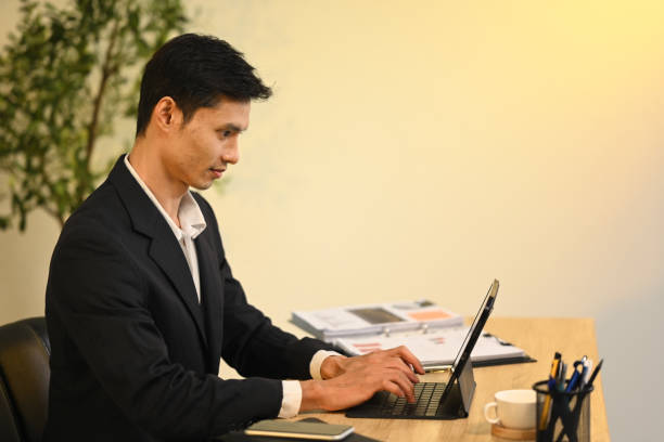 istock Focused professional businessman working on important project with digital tablet at office 2184864798