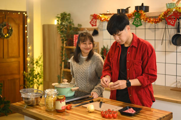 istock Young couple cooking together for Christmas celebration in decorated kitchen 2184864848