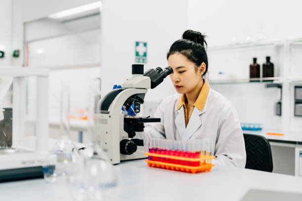 istock Asian female scientist looking trough the microscope in lab. 2184874807