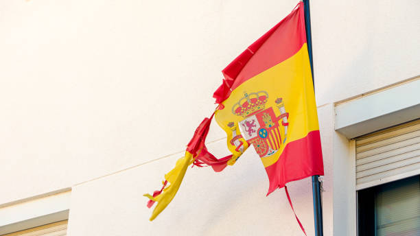 istock A worn Spanish flag waves from a pole, with frayed edges and torn fabric. 2184878604