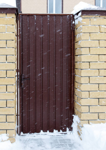 istock A brown door with snow on it is in front of a brick wall 2184884080