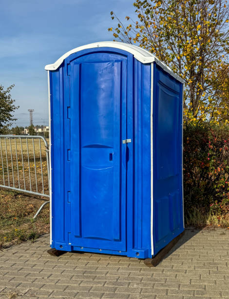 istock A blue portable toilet is sitting in front of a tree 2184884351