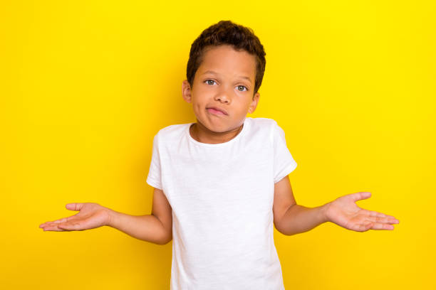 istock Photo of cute stylish boy arm shoulder raise dont know question oops sorry look empty space isolated on yellow color background 2184890726