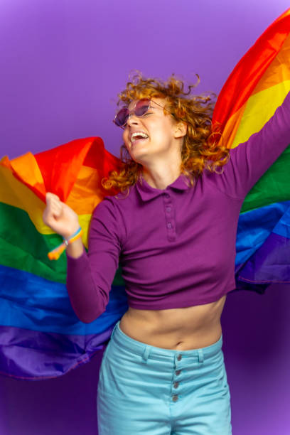 istock Woman dancing raising lgbt rainbow flag 2184892336