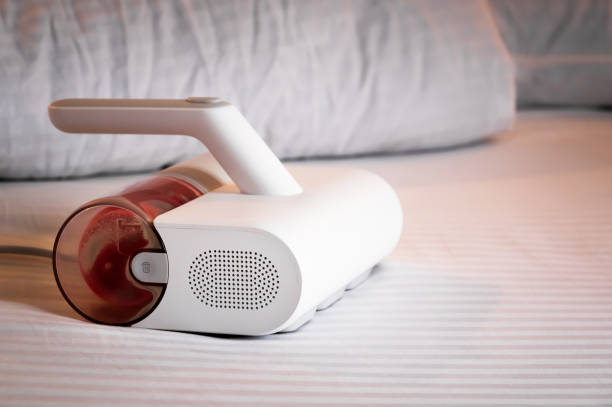 istock Specialized vacuum cleaner for removing linen mites and disinfecting bed linen and bedding. Vacuum cleaner with UV lamp on the bed 2184892591