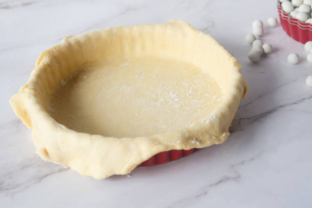 istock pastry pie dough in pie plate on white marble table preparation for bake. 2184892685