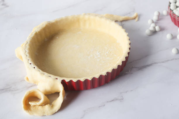 istock pastry pie dough in pie plate on white marble table preparation for bake. 2184892750