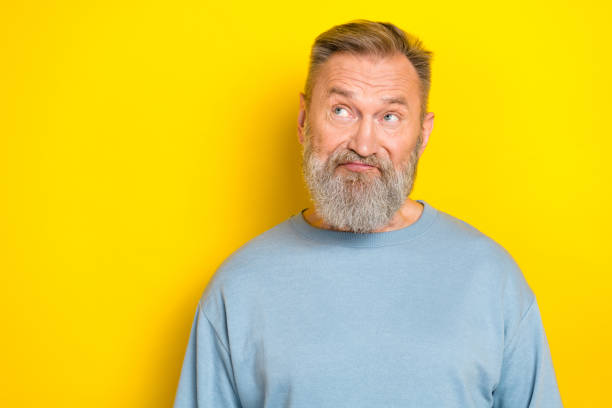 istock Photo of suspicious funny man pensioner dressed blue pullover looking empty space isolated yellow color background 2184894205