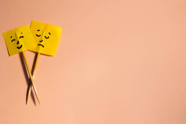 istock Two yellow square papers with smiley and sad face mood concept 2184897470