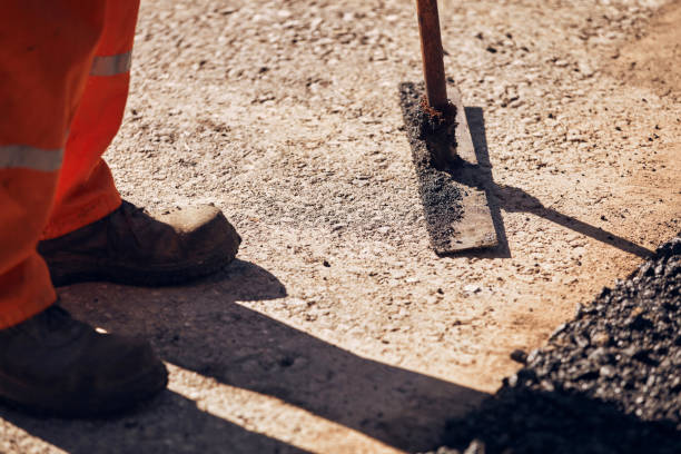 istock Construction workers working on a new asphalt layer on a public street. 2184897546