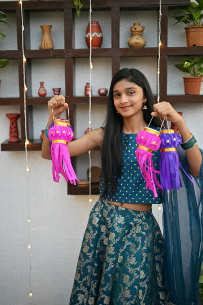istock Girl holding lanterns, smiling at the camera on the terrace 2184898413