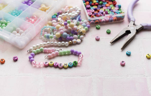 istock Colorful beads and pliers arranged on pink tile for jewelry making 2184898442