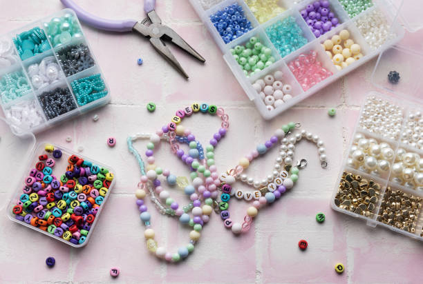 istock Colorful beads and jewelry making tools arranged on pink tile surface 2184898447