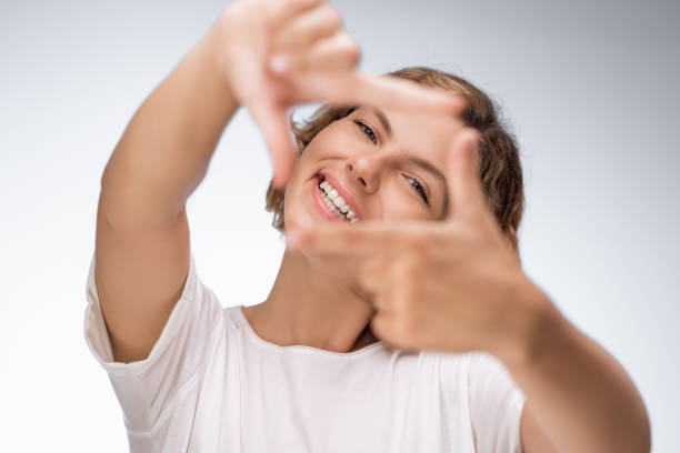 istock Smiling Woman Framing Her Face With Hands in a Creative Gesture 2184905503