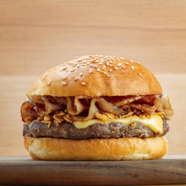 istock Fresh burger with cheese on wooden background 2184905533