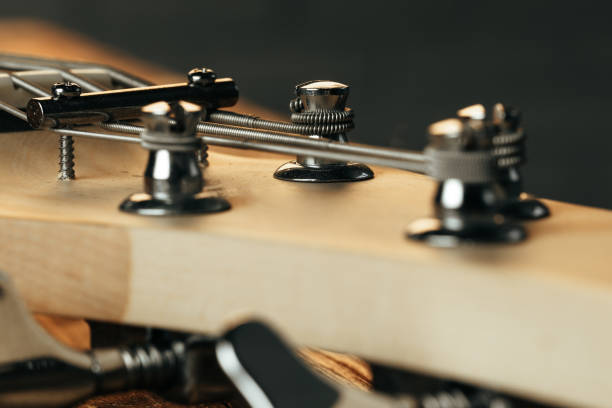 A close-up image of a bassist's hand pressing the frets of an electric bass. The blurred background with vibrant lights creates an artistic and dynamic atmosphere, conveying the essence of live music, creativity, and passion for the bass