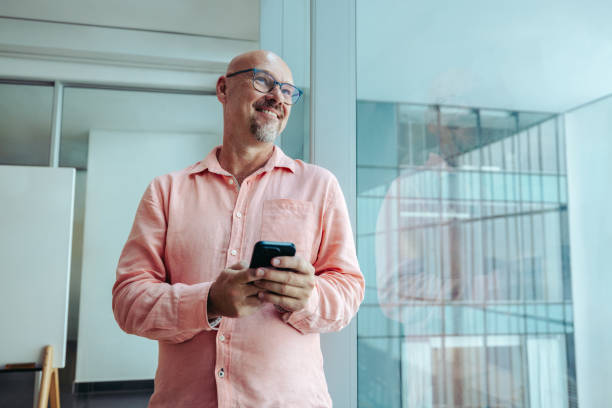 istock Mature professional entrepreneur smiling confidently while using a smartphone 2184907431