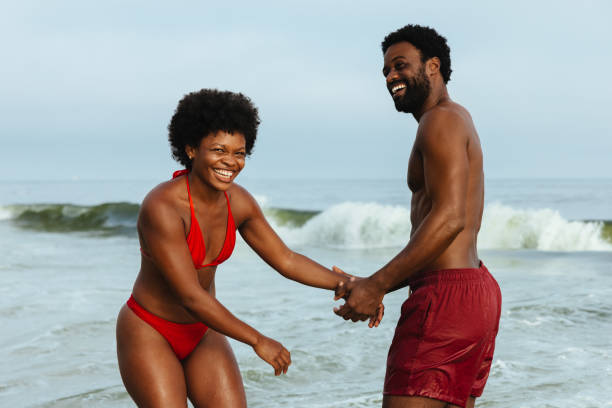 istock Joyful couple having fun at the beach enjoying sunny day 2184910422