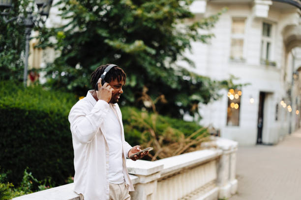 istock Young smiling man  laughing, singing and streaming audio or radio on wireless headset 2184912416