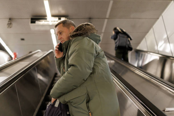istock Man talking on smart phone on subway station escalator 2184912923