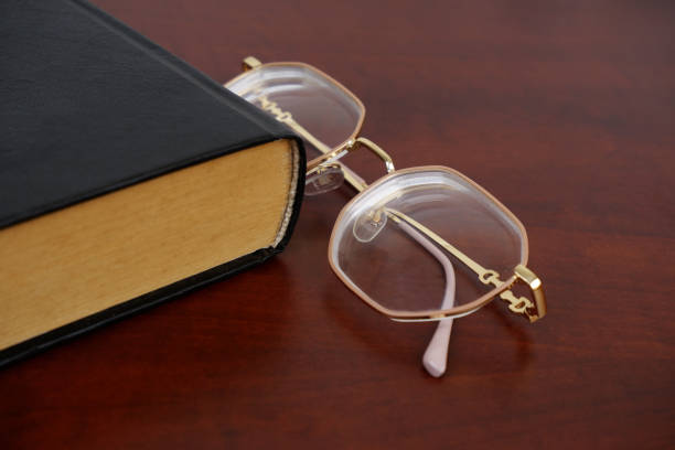 istock Female reading eyeglasses and book on table 2184912990
