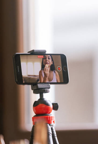 istock Young  woman is applying makeup and giving techniques to audience while live streaming. 2184915622