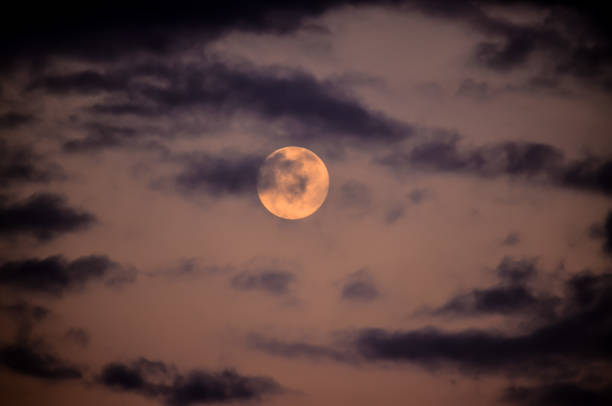istock A large moon is visible in the sky, surrounded by clouds 2184916241