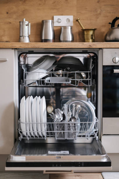 istock Modern kitchen with a dishwasher full of clean plates and utensils. 2184916591
