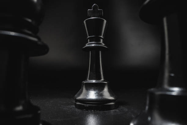 Chess game with chess pieces against black background close up