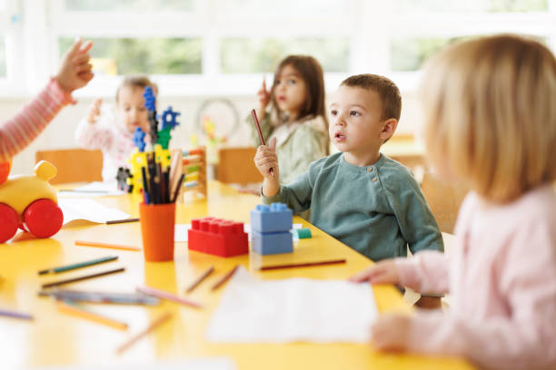 istock Little boy sitting on a chair while drawing in kindergarten 2184920870