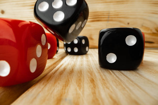Red and black dice cubes on wooden background