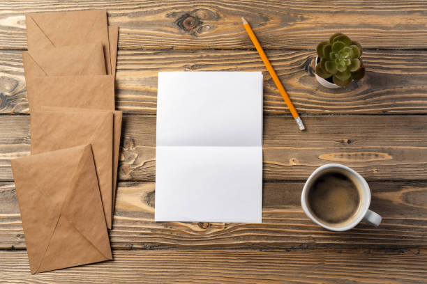 istock Vintage envelope with empty card, pen on wooden table top view 2184923686