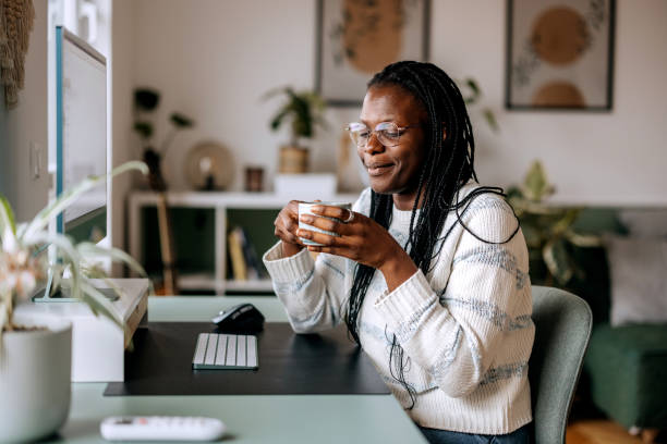 istock Casually clothed woman enjoying coffee at home office 2184923743