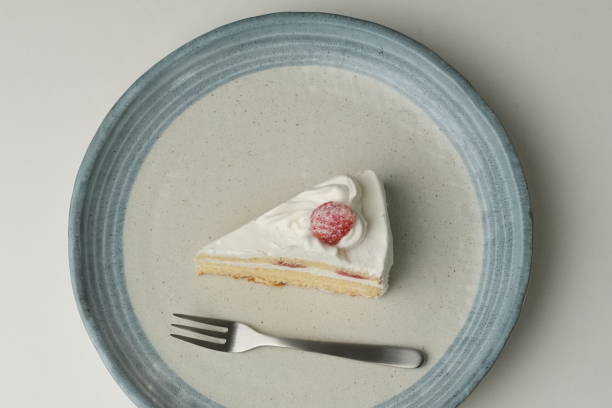 istock One small Japanese strawberry shortcake and a big fork on a stylish big plate on a white table 2184924953