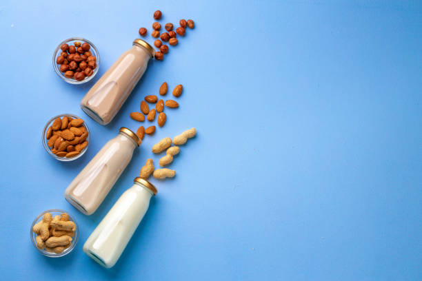 istock Bottles of vegan non dairy milk with various nuts on blue background 2184927046