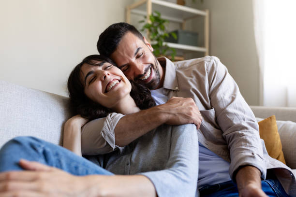 istock Affectionate happy couple in love hugging, relaxing on the couch. 2184928021