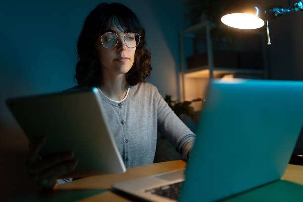 istock Woman working late at night using laptop and digital tablet. Deadline. 2184928116