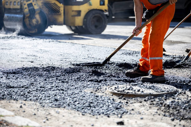 istock Workers repair a city road using asphalt during bright daylight, showcasing construction efforts at a busy location 2184929208