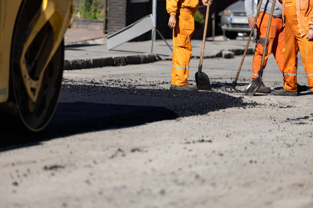 istock Construction workers paving a road using heavy machinery on a sunny day in an urban setting 2184929696
