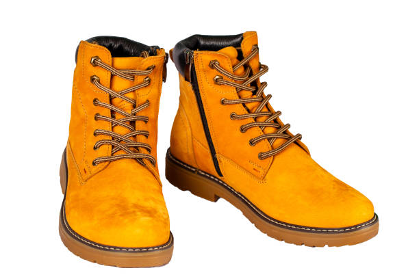 Pair of beige leather boots with laces, featuring a sturdy sole and detailed stitching. Isolated on a white background, ideal for fashion, outdoor gear, or product advertising.