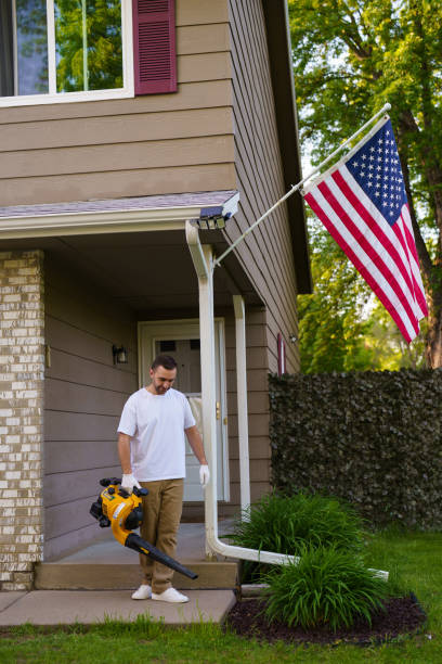 istock A young bearded man using a cordless, electric leaf blower in a garden. Garden works. 2184934224