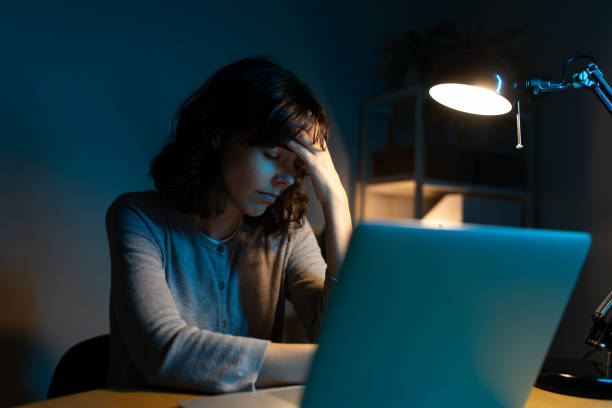 istock Tired woman working late at night using laptop at home office having headache. 2184934524