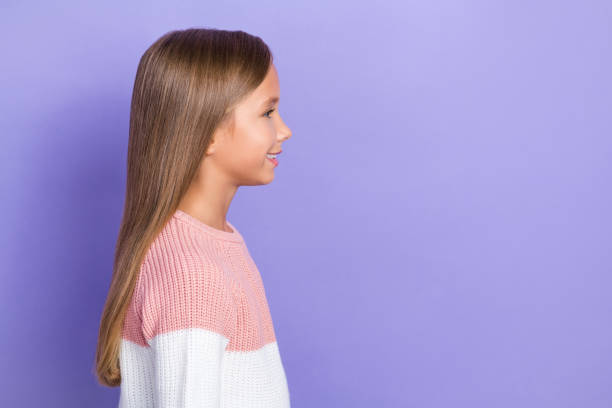 istock Profile side photo of attractive little lady look empty space dressed colorful pullover toothy smile isolated on purple color background 2184934974