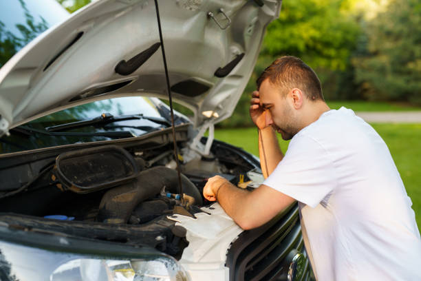 istock Stressed man having trouble with his broken car looking in frustration at failed engine 2184936543