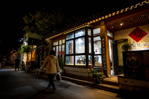 Beijing, China. 6 November 2024. Shoppers explore the narrow alleys of Dongcheng  Hutong in Beijing at night