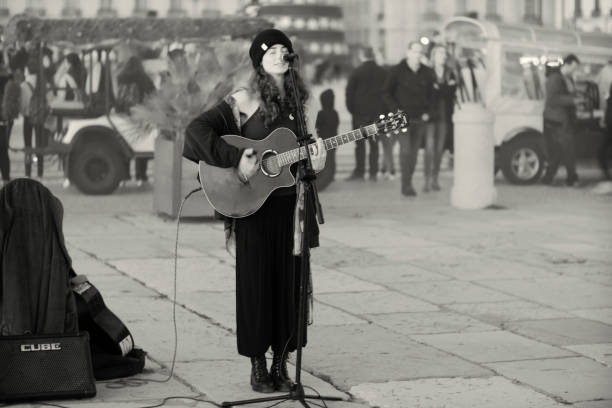 Lisbon, Portugal - December 17, 2022: A female street musician performs at the Praça do COmércio square in Lisbon downtown.