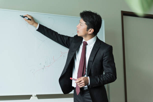 istock Employees having a serious meeting using a whiteboard 2184936958