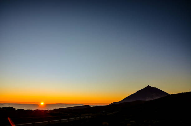 istock A mountain is silhouetted against a beautiful sunset sky 2184938640