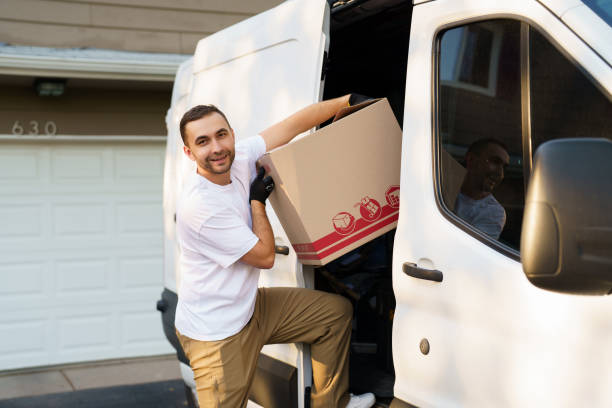 istock Young delivery man loading cardboard boxes from truck. Delivery concept 2184938876