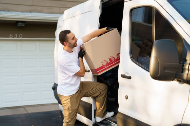 istock Courier with delivery cardboard box by the car. Delivery concept 2184939004